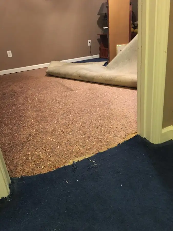Carpet pad removal revealing water damage during Water Mitigation Services in Stowe